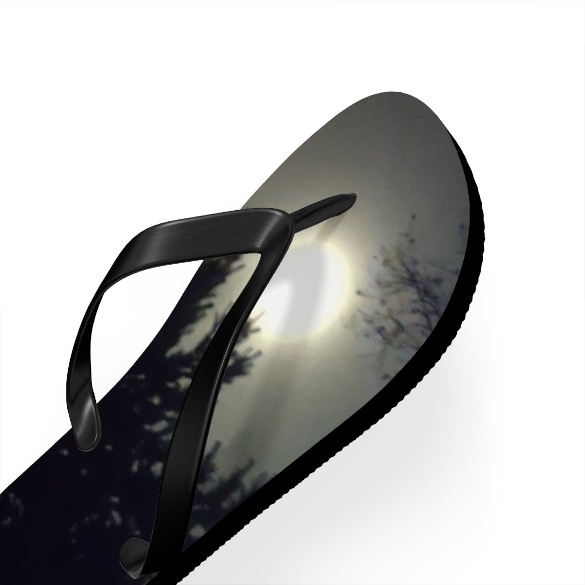 Black flip-flop with a moonlit forest scene printed on the sole.