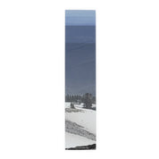 Snowy mountain landscape with trees, against a blue sky.