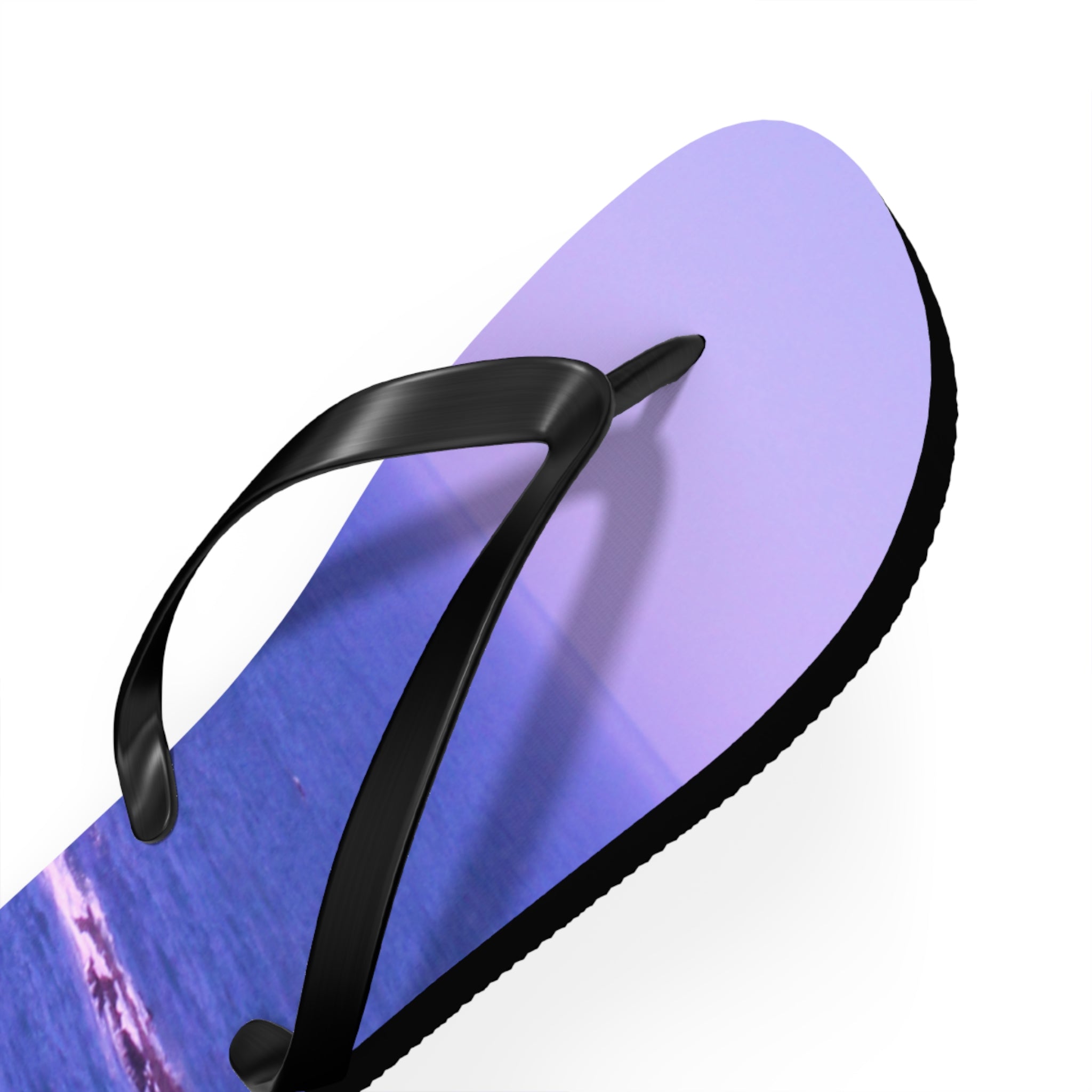Purple flip-flop with ocean wave detail and black strap.