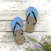 Blue flip-flops with a woodgrain pattern on a light wooden surface.