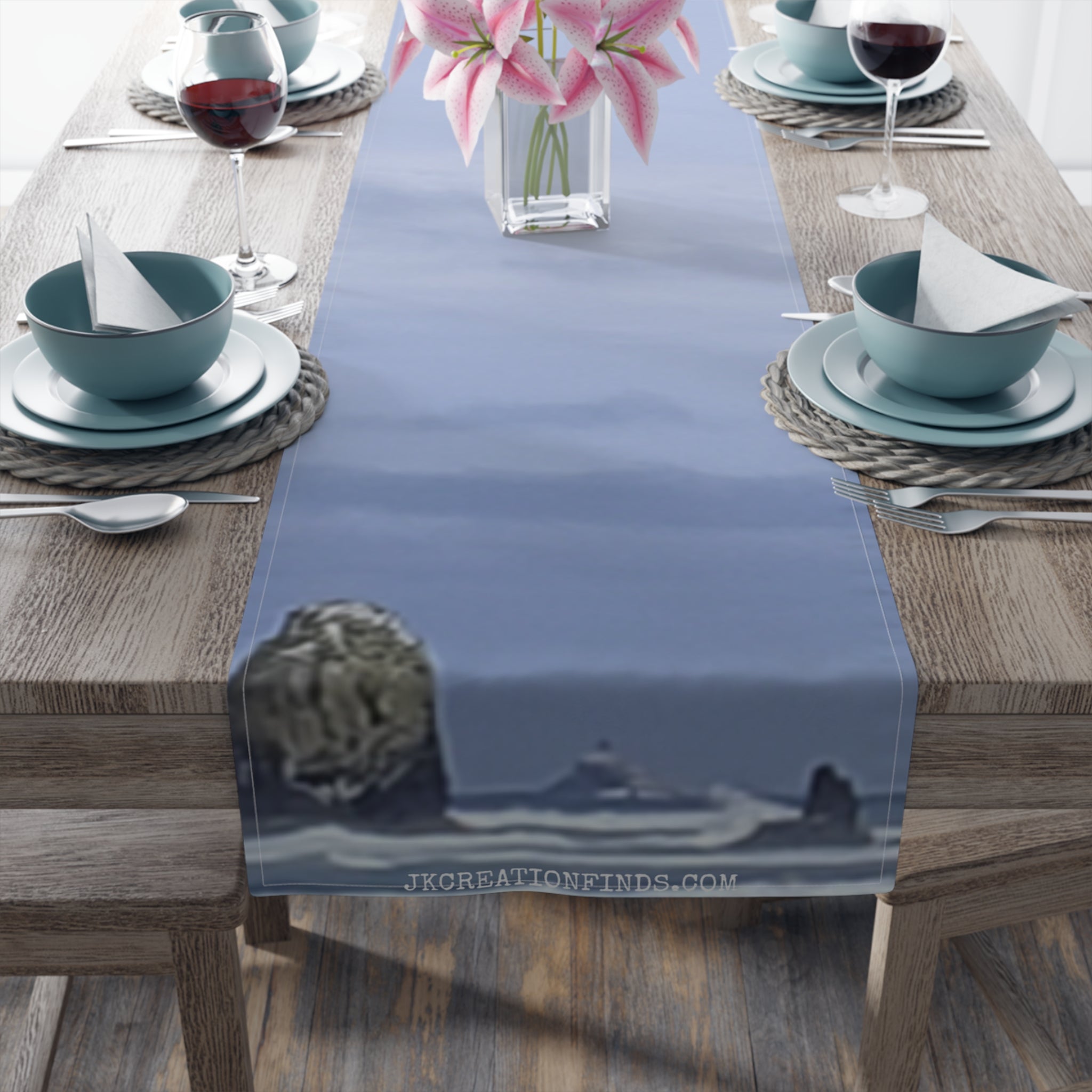 Table runner with a blurry seascape design of a lighthouse and rocks.