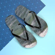 Black flip-flops with wave pattern on a blue and white background.