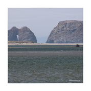 Coastal rock formations with a natural arch visible.
