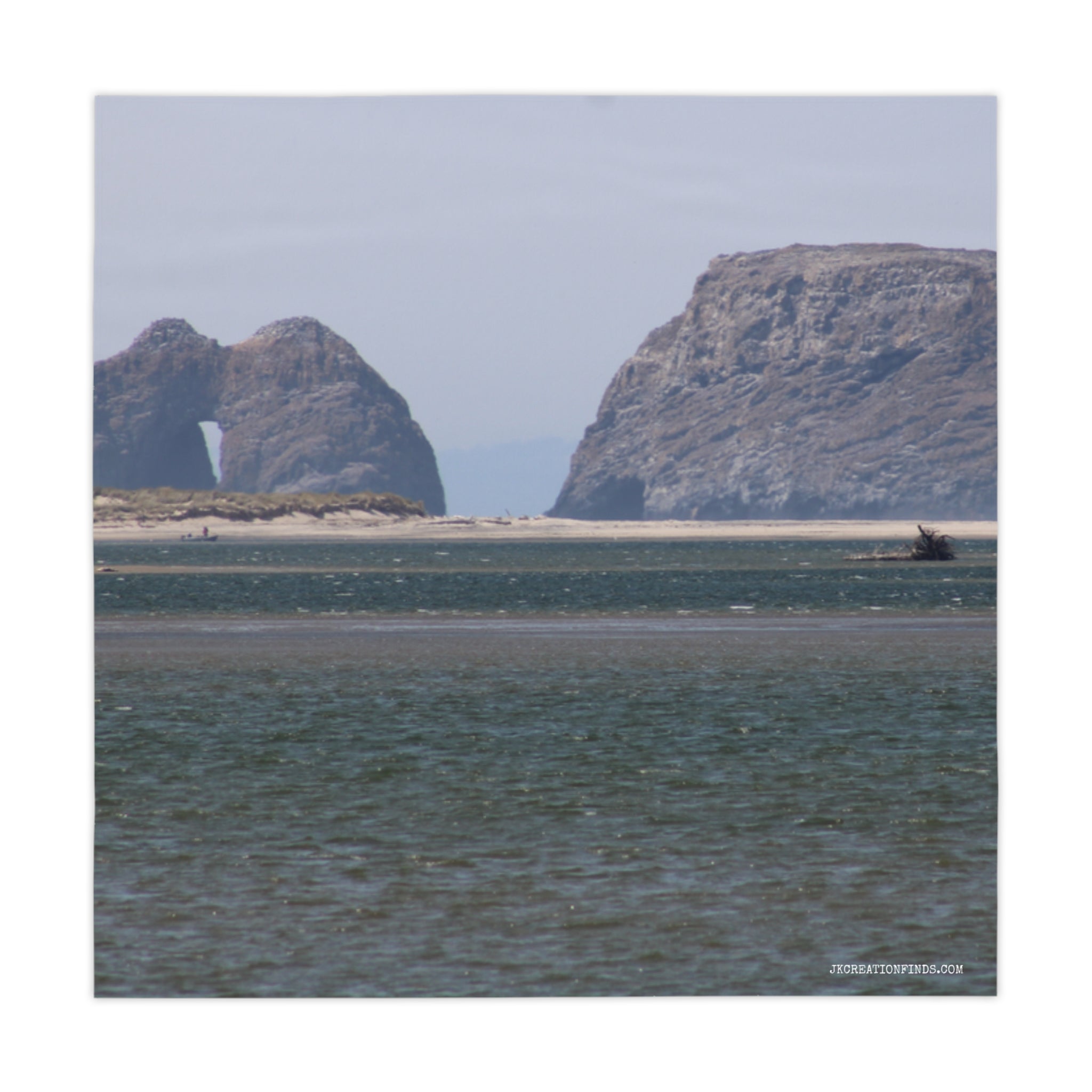 Coastal rock formations with a natural arch visible.
