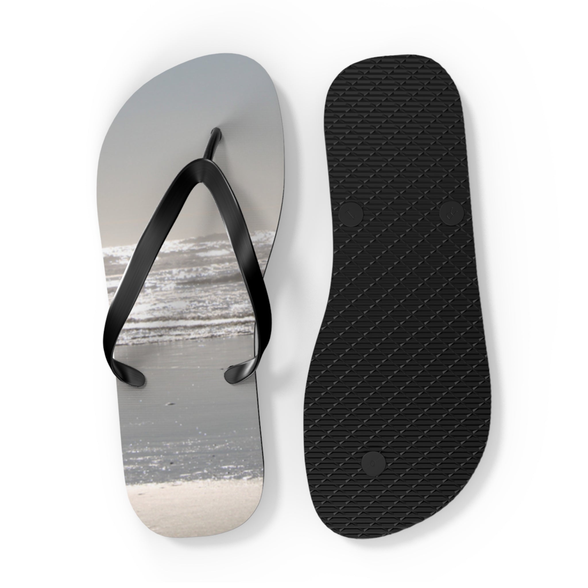 Flip-flops with a beach wave design on one sole and textured black on the other.