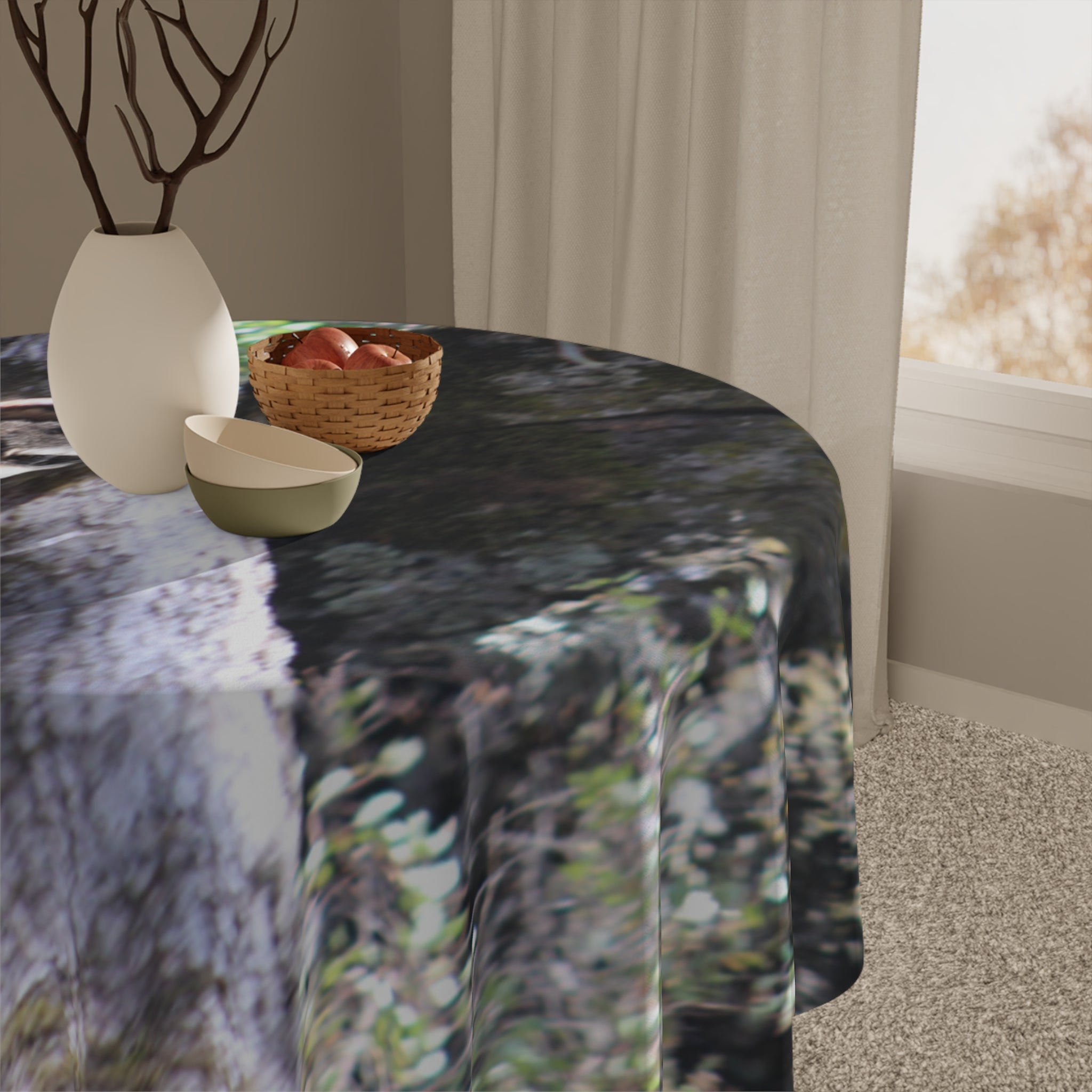 Round tablecloth with a nature-inspired pattern, holding a vase and fruit bowl.