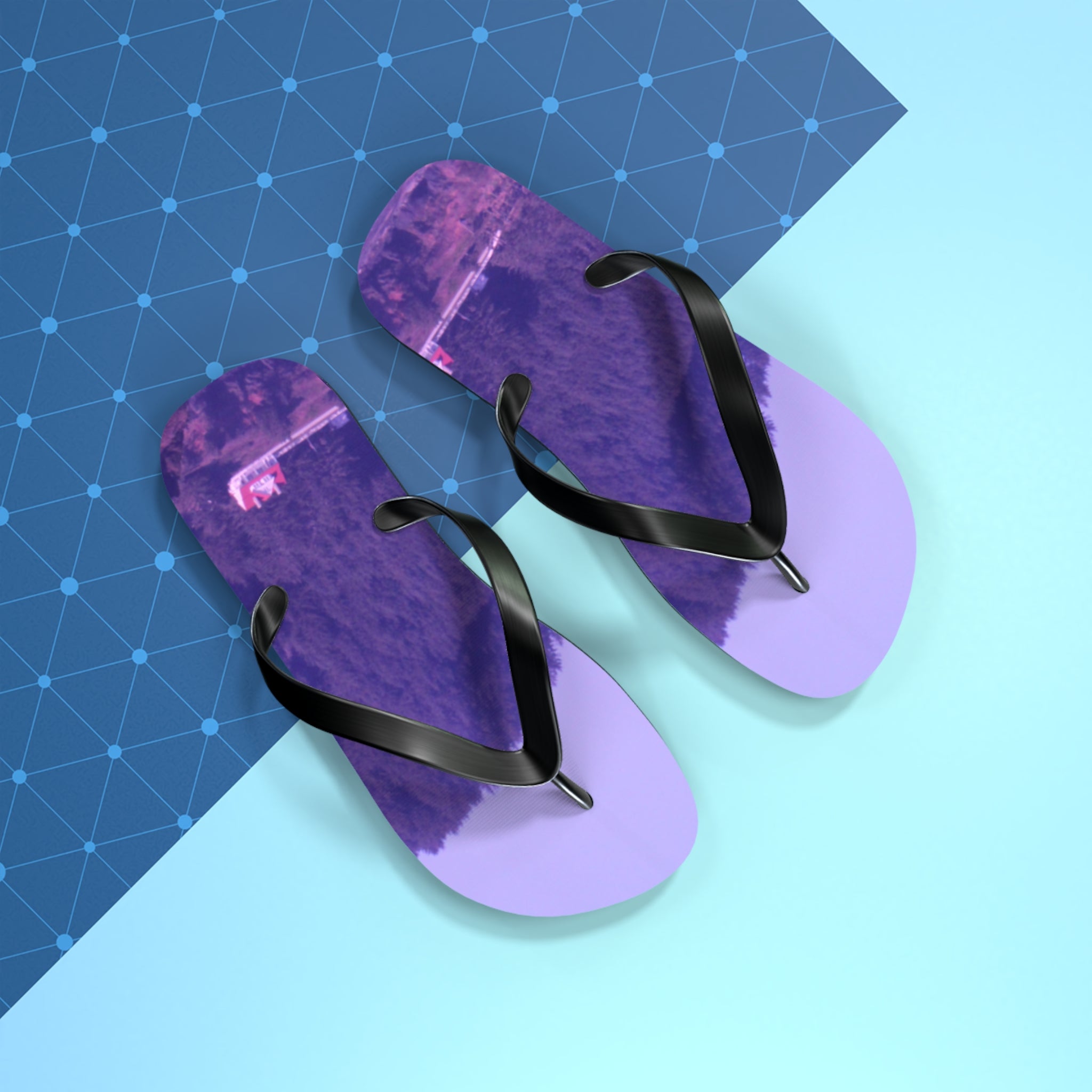 Purple flip-flops with black straps on a light blue background with a grid pattern.