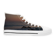 White high-top sneaker with a sunset scene of dolphins leaping from ocean waves.