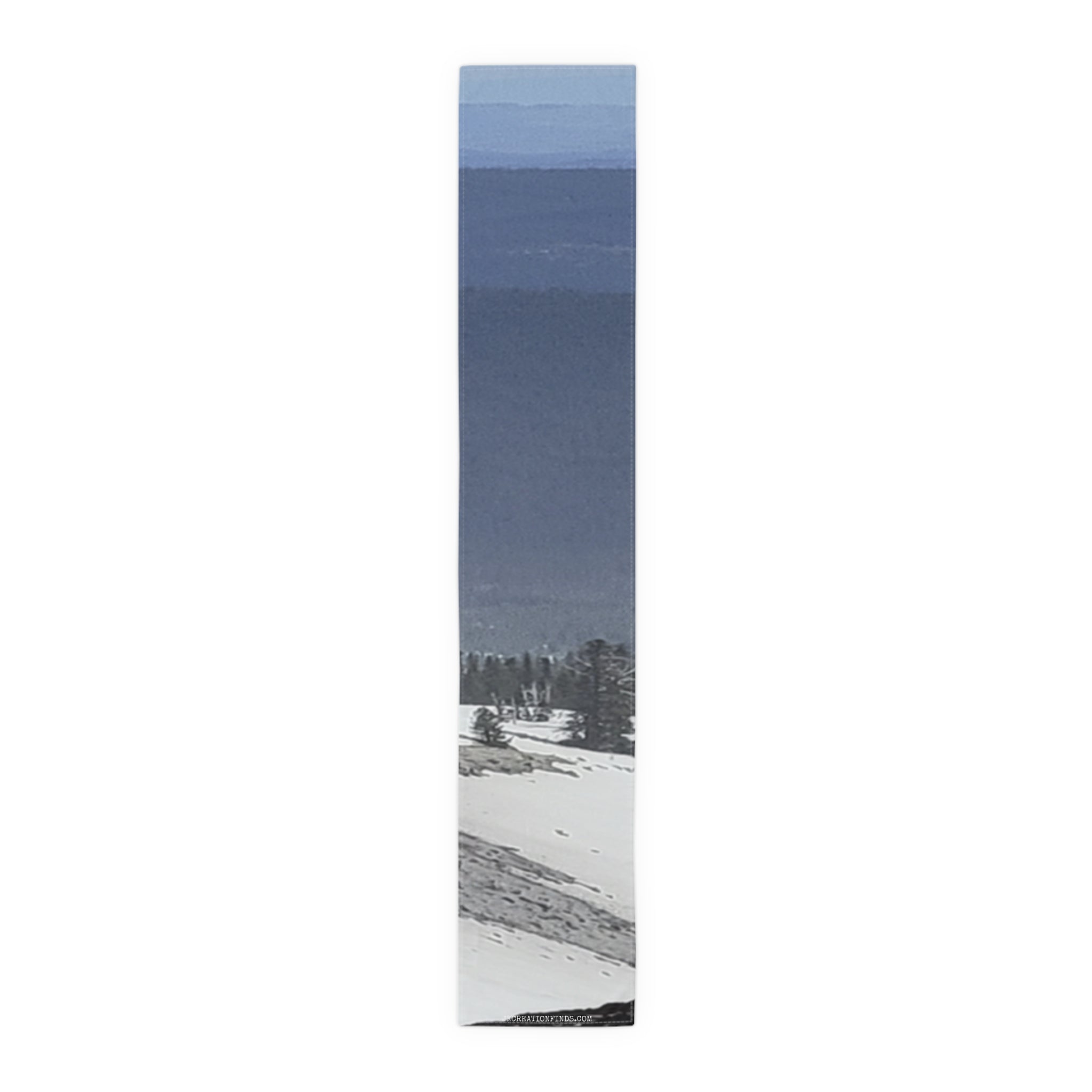 Mountain range under blue sky, with snow-covered slopes in the foreground.