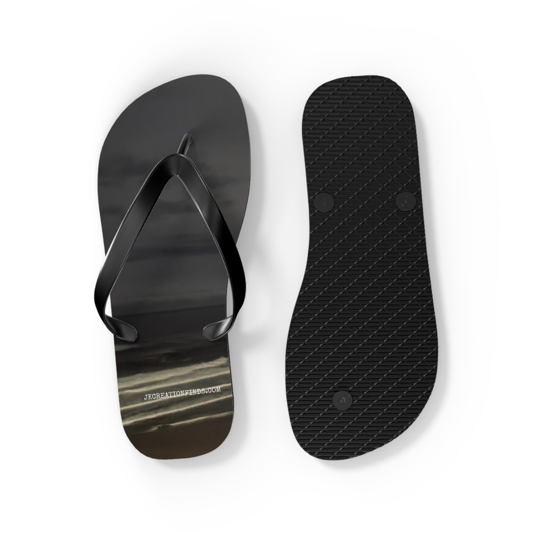 Black flip-flops with a cloudy sky graphic and textured sole.