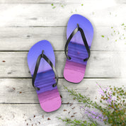 Purple and pink ombre flip-flops with a beach scene design on a wooden surface.