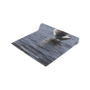 Rolled yoga mat with a seagull on water printed on its surface.