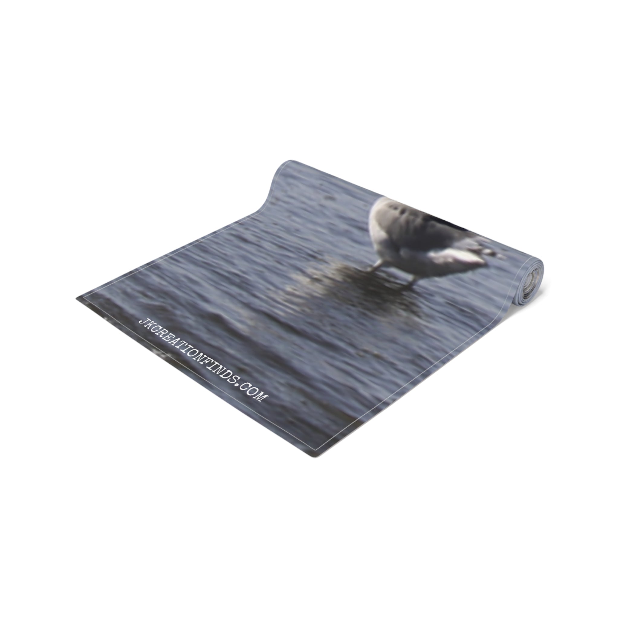 Rolled yoga mat with a seagull on water printed on its surface.