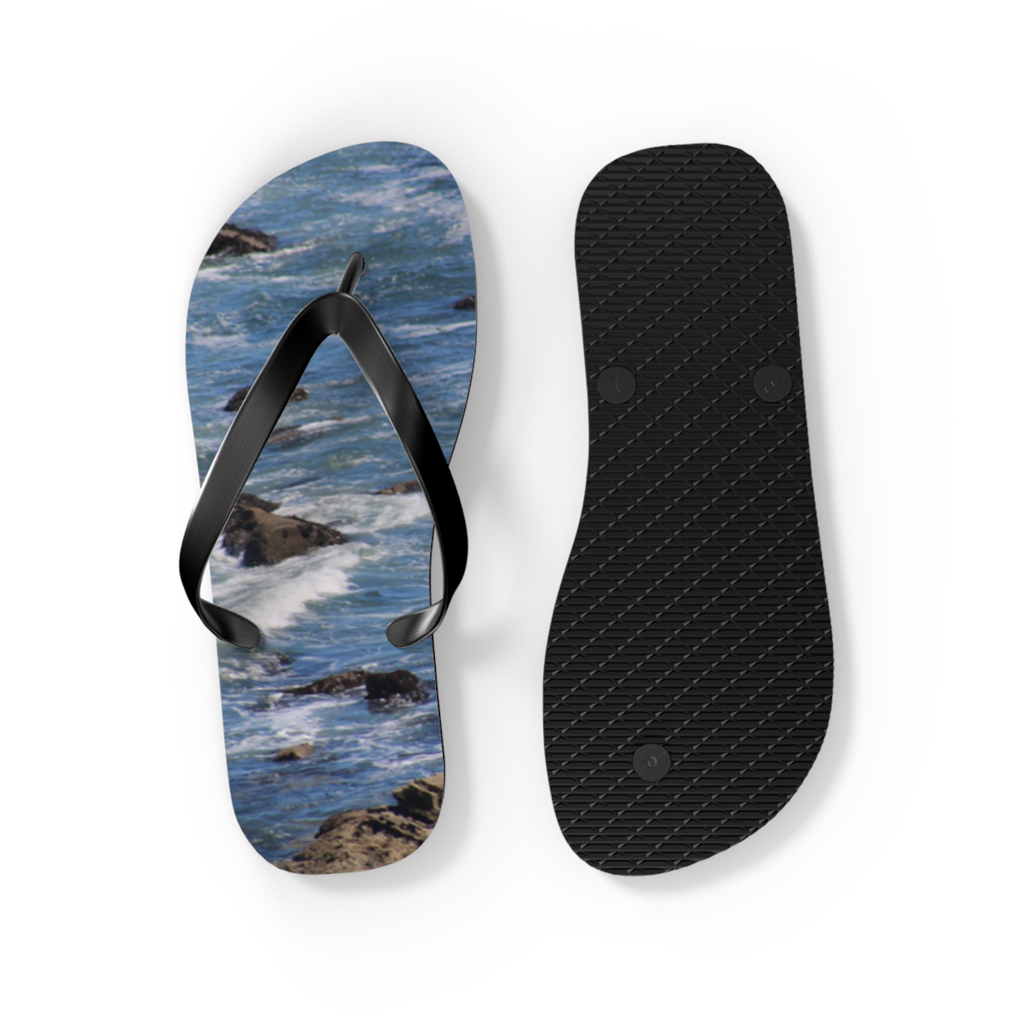 Flip-flops with ocean waves on one sole and black treads on the other.