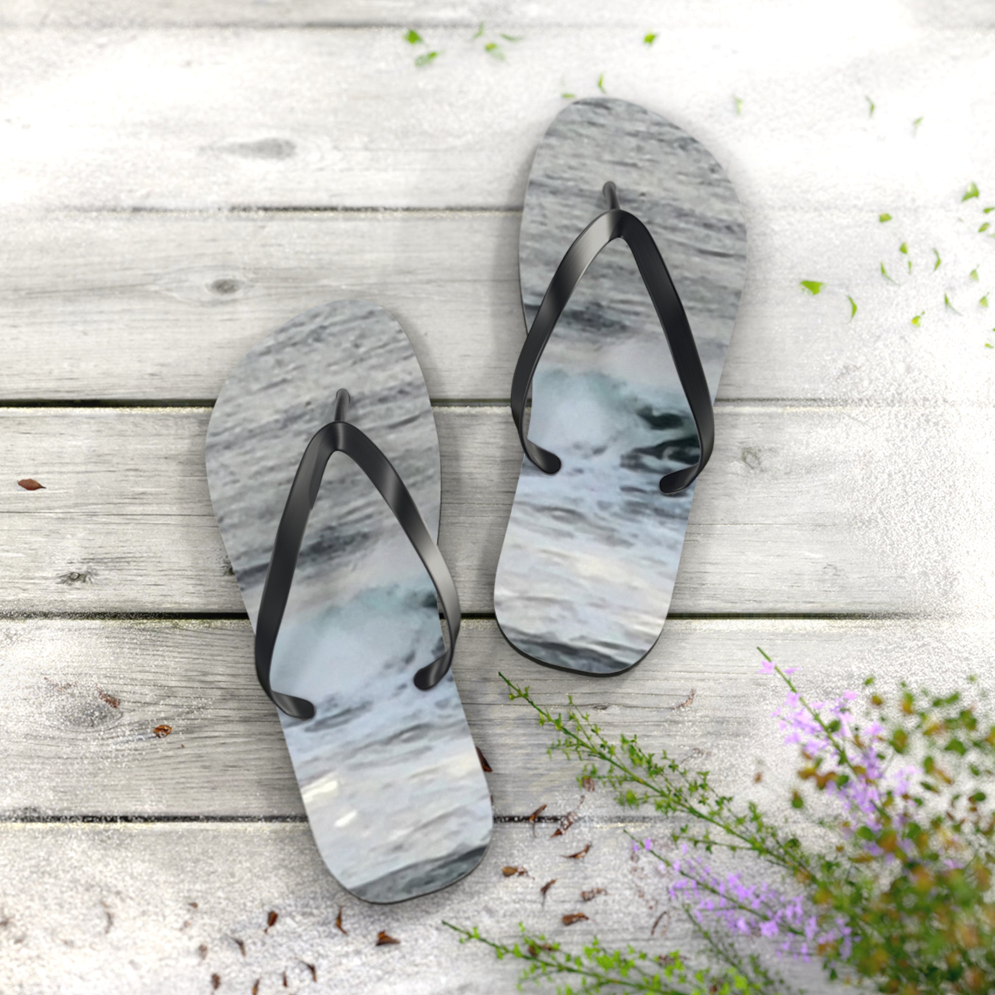 Flip-flops with ocean wave pattern on a wooden surface.