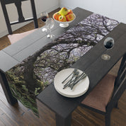 Tree branch pattern runner on dark wood dining table with place settings.