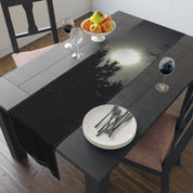 Dark forest moon scene on a black table runner with plates and silverware.