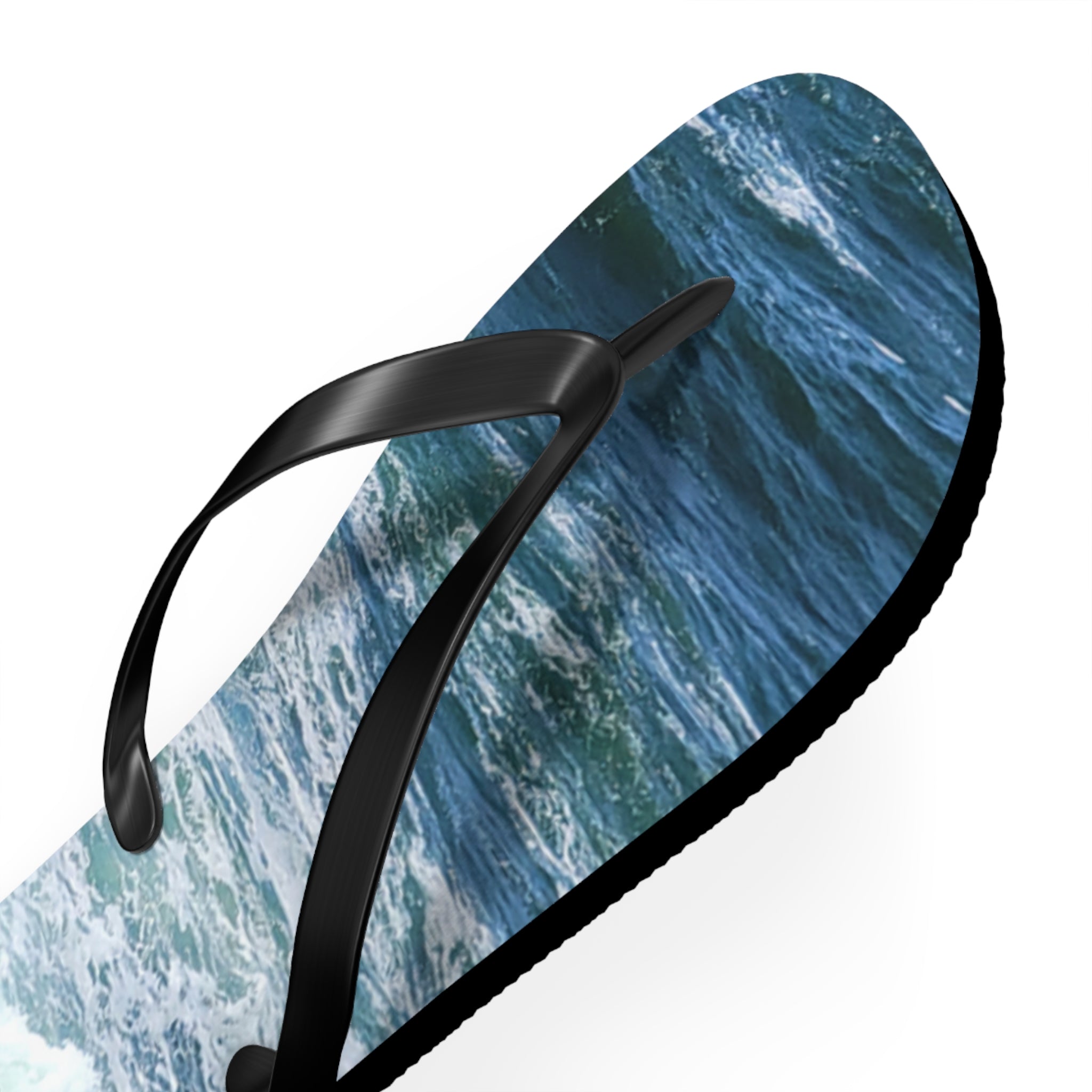 Black flip-flop with ocean waves printed on the sole.
