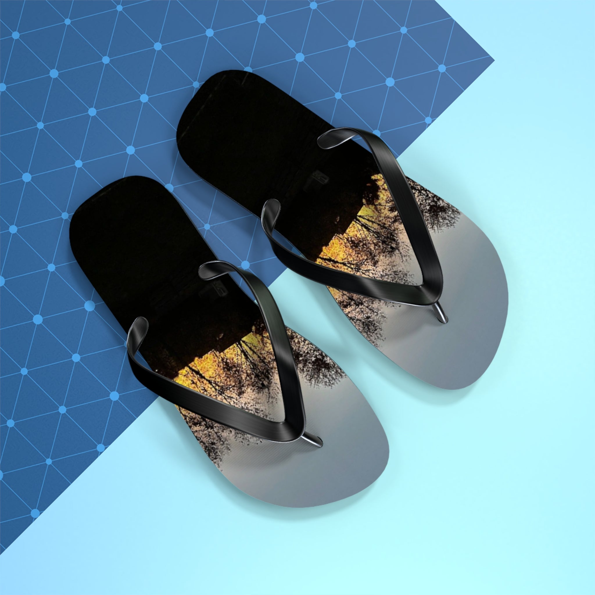 Black flip-flops with a sunset tree reflection on the straps.