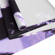 Rolled fabric with a blurred purple and white floral pattern.