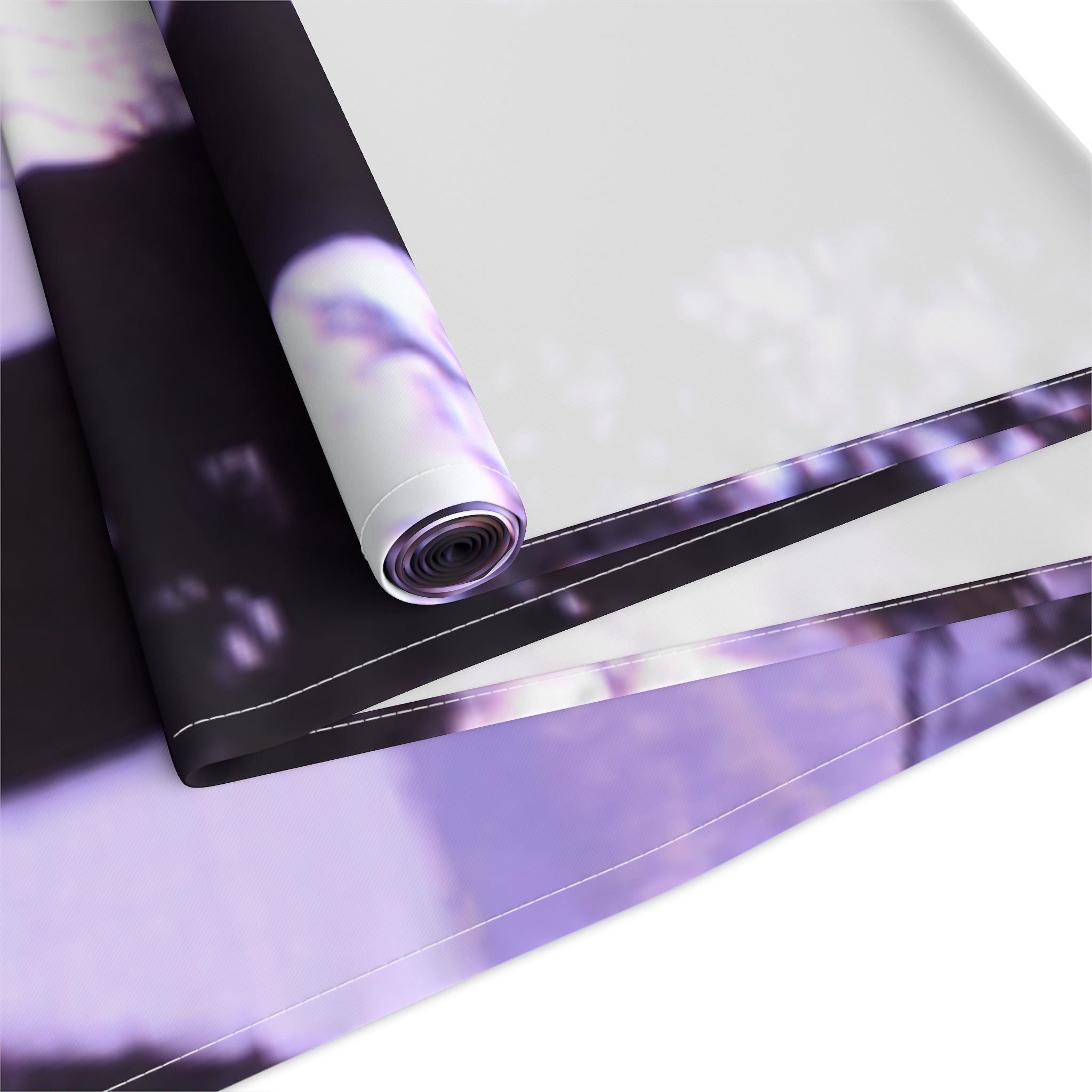 Rolled fabric with a blurred purple and white floral pattern.