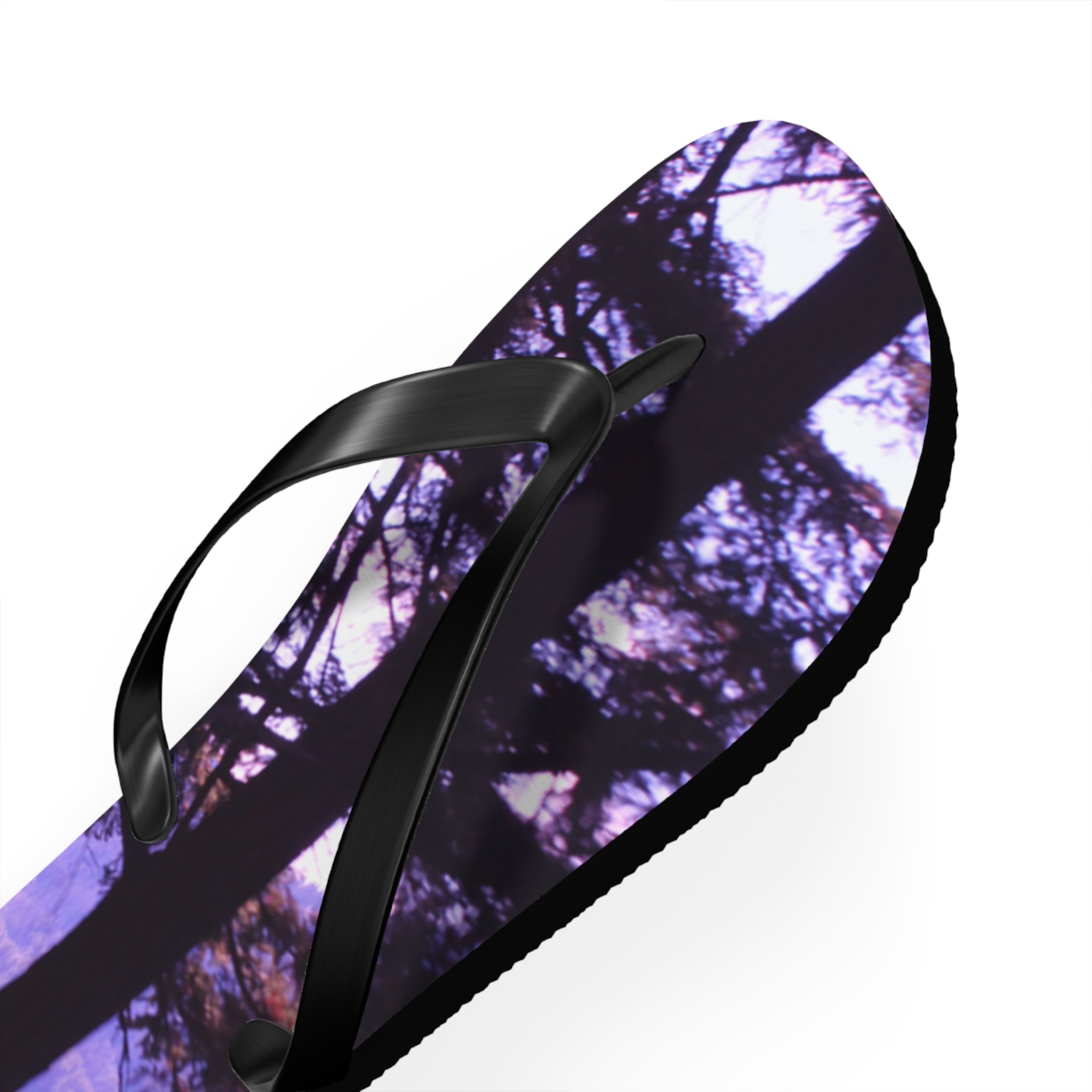 Flip flop with purple and green tree pattern and black strap.