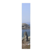 Tall, narrow artwork showing a rocky coastline with waves and dry grass.