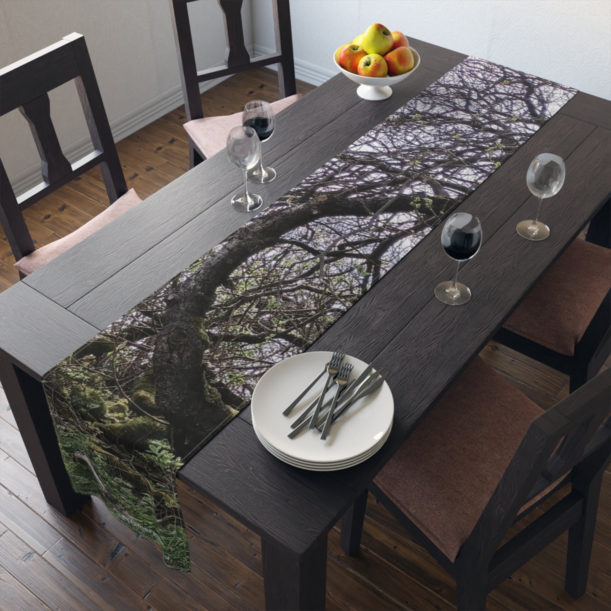Table runner with a mossy tree branch pattern, set on a dark wood table.