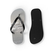 Flip flops with a beach scene on the soles, one shown from above.