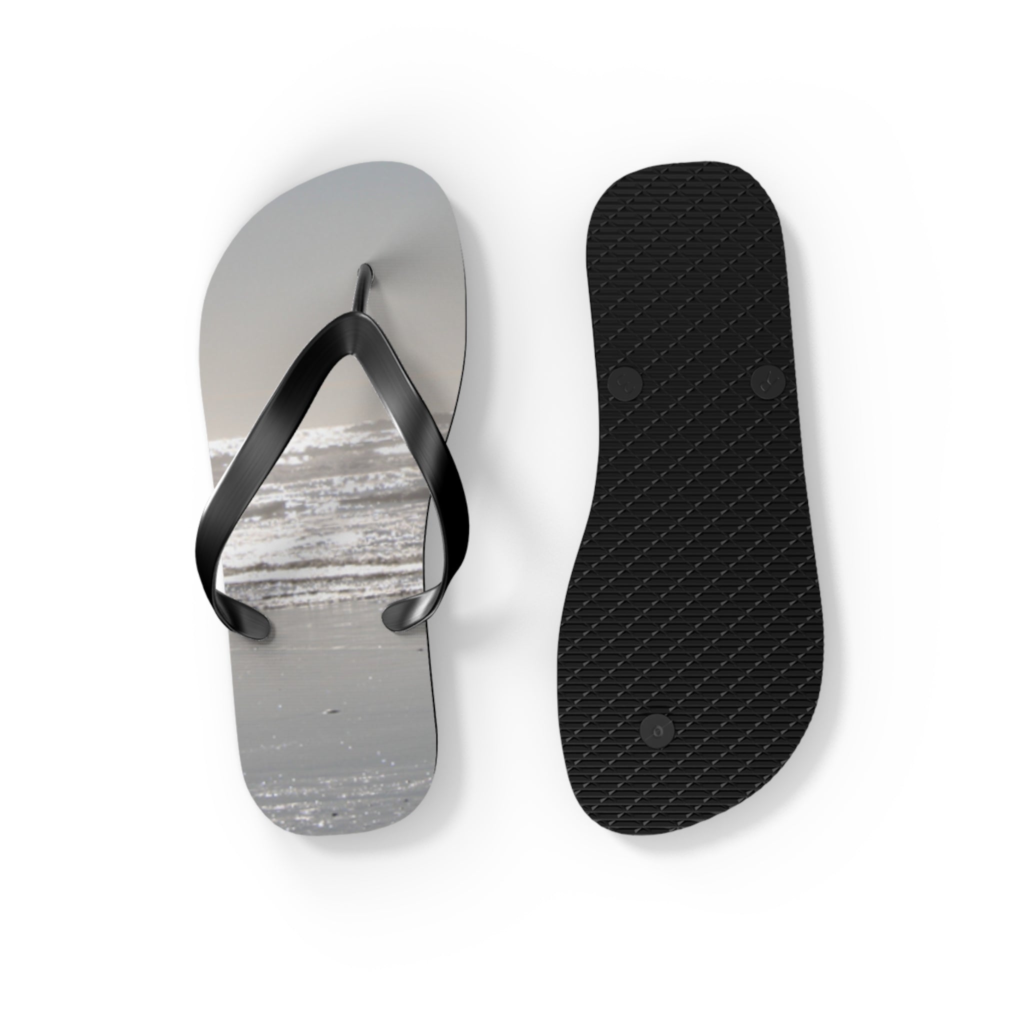 Flip flops with a beach scene on the soles, one shown from above.