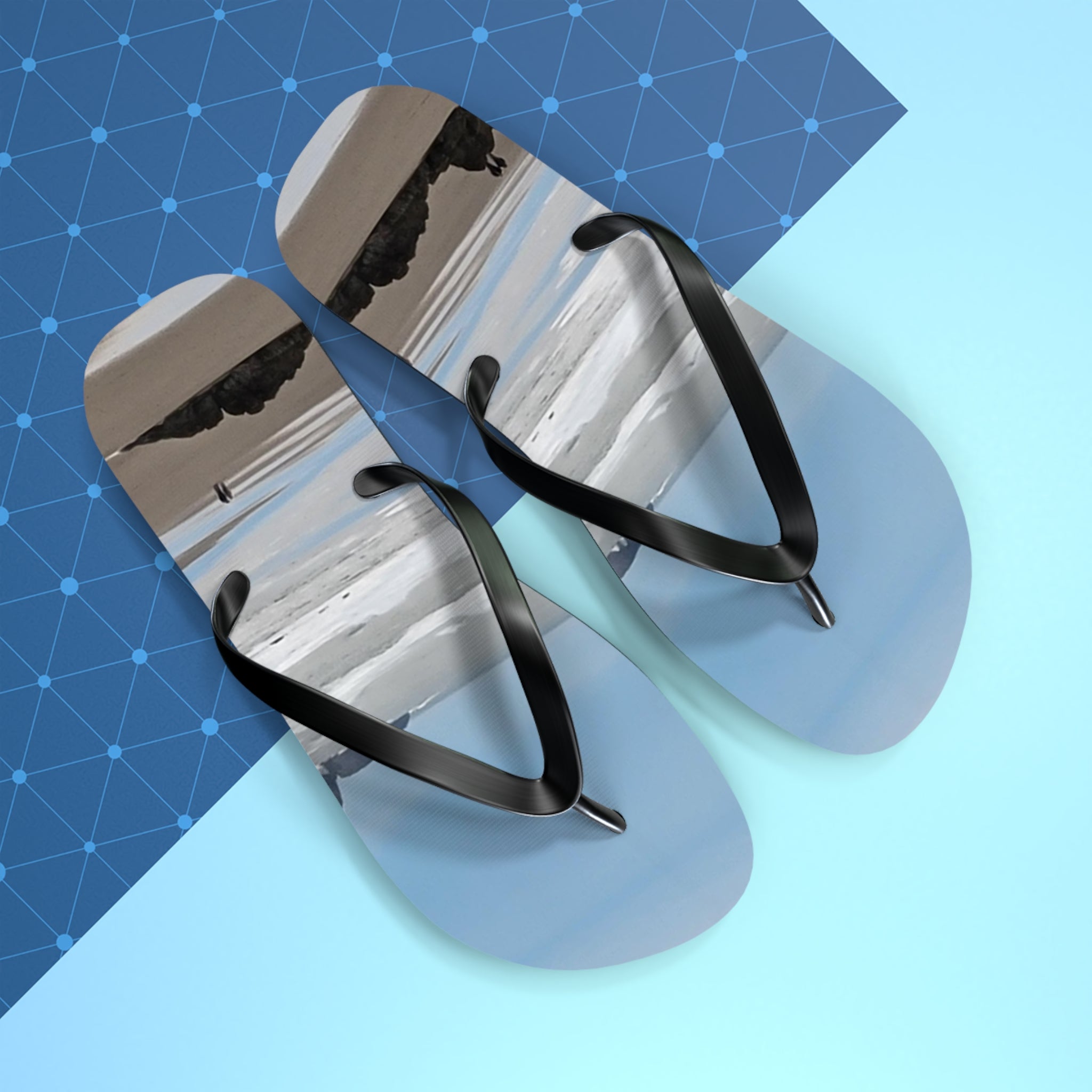 Flip-flops with a beach landscape on a blue geometric background.