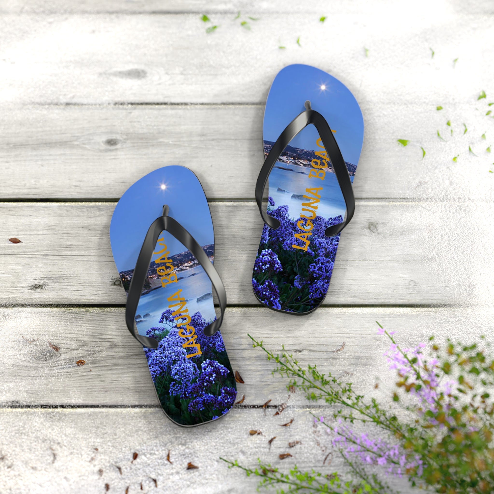 Flip-flops with a scenic view of Laguna Beach and purple flowers.