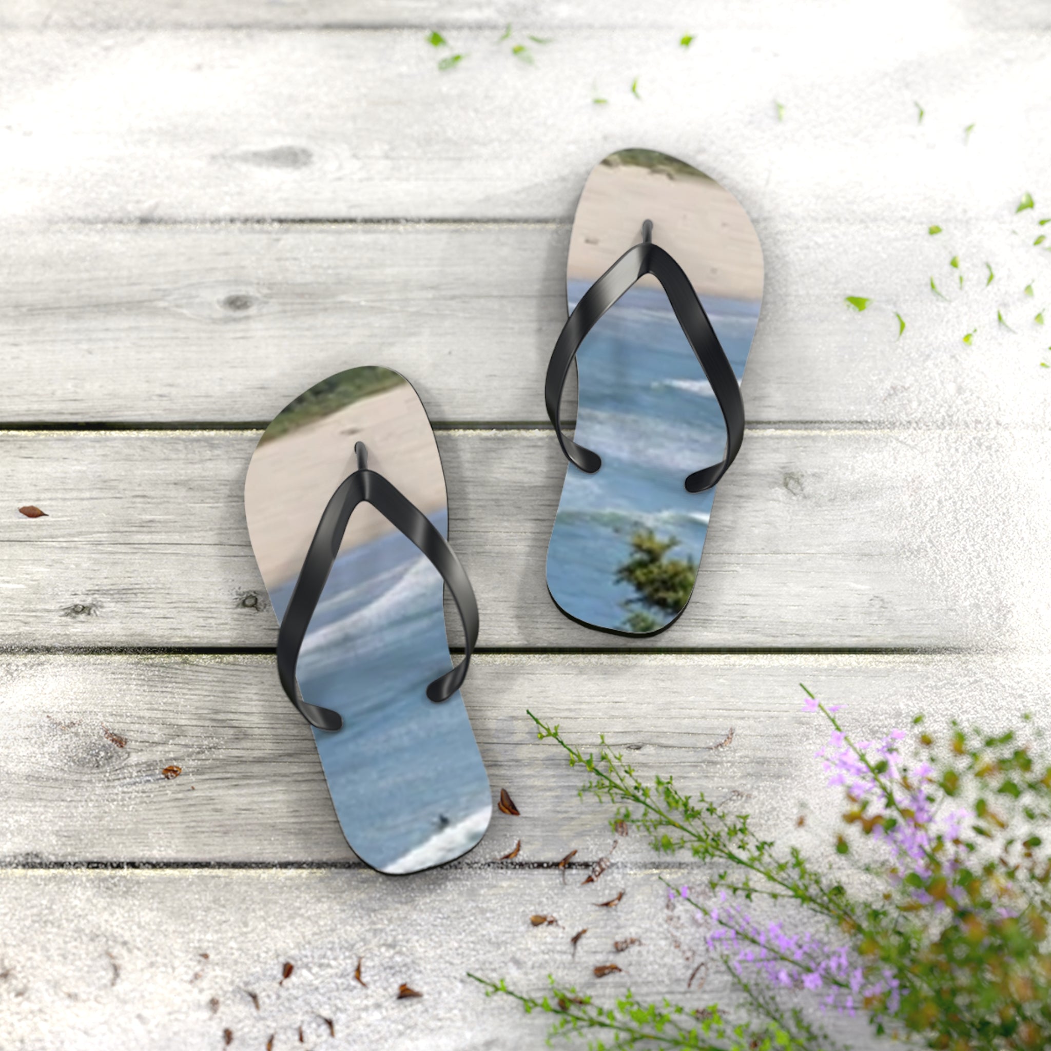Flip-flops with a beach and ocean scene, resting on a wooden surface.