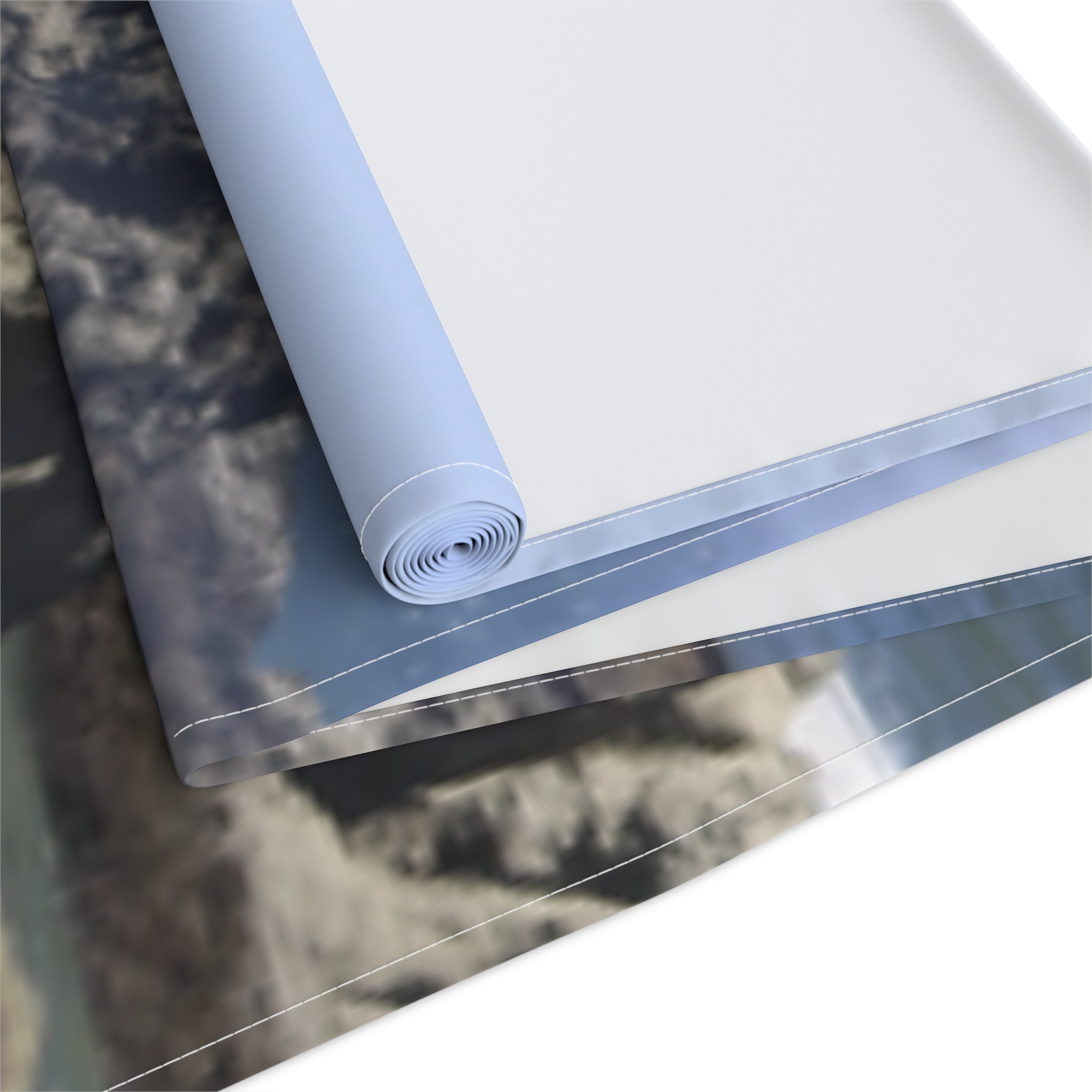 Rolled canvas fabric with a cloudy sky landscape print.