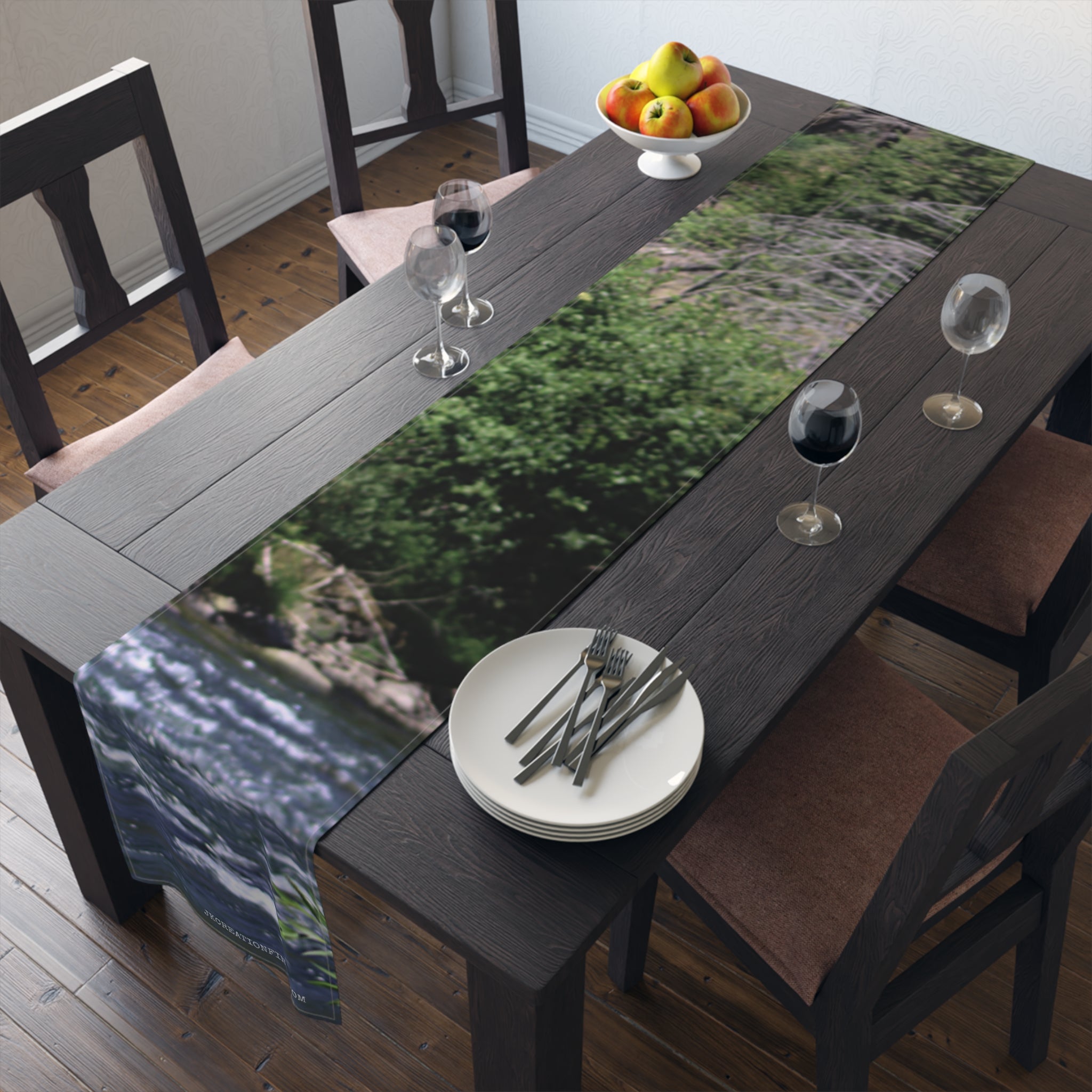 Dark wooden dining table with a scenic nature print table runner.