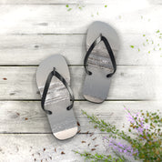 Flip-flops with a beach and ocean scene printed on the soles.