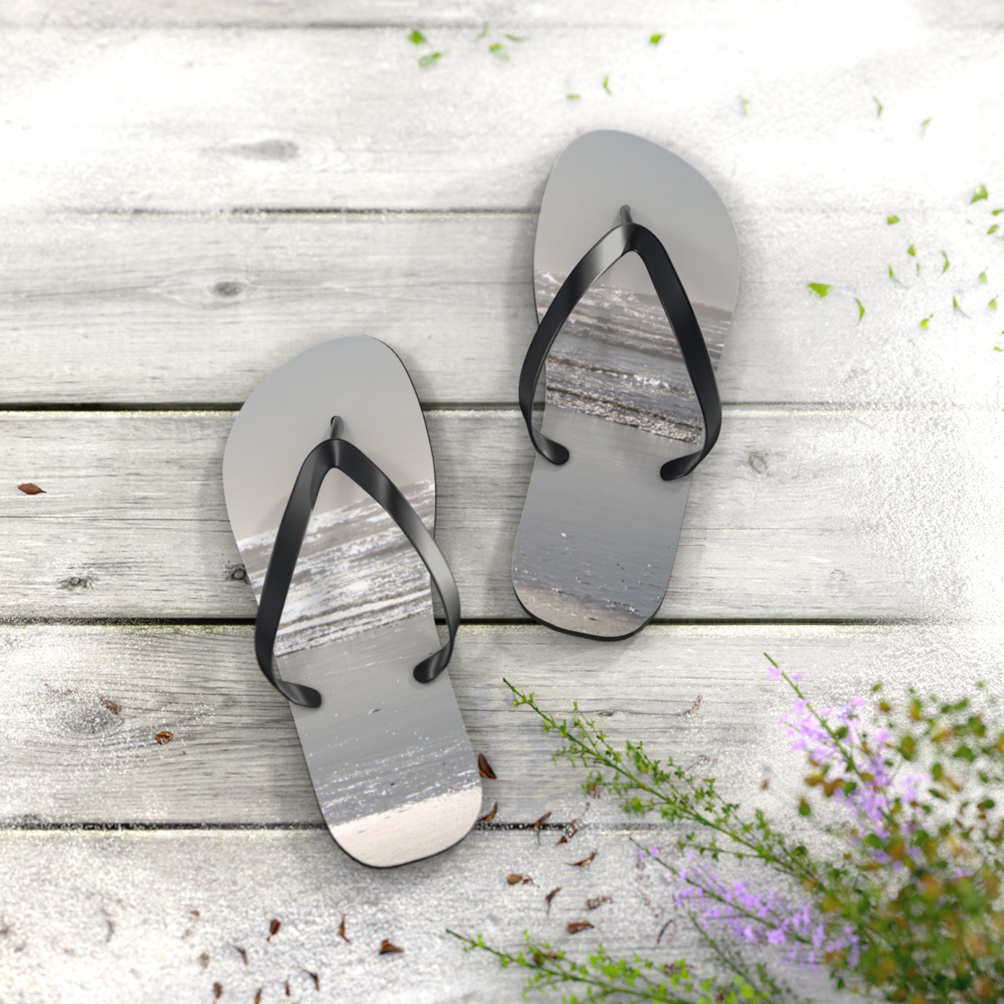 Flip-flops with a beach and ocean scene printed on the soles.