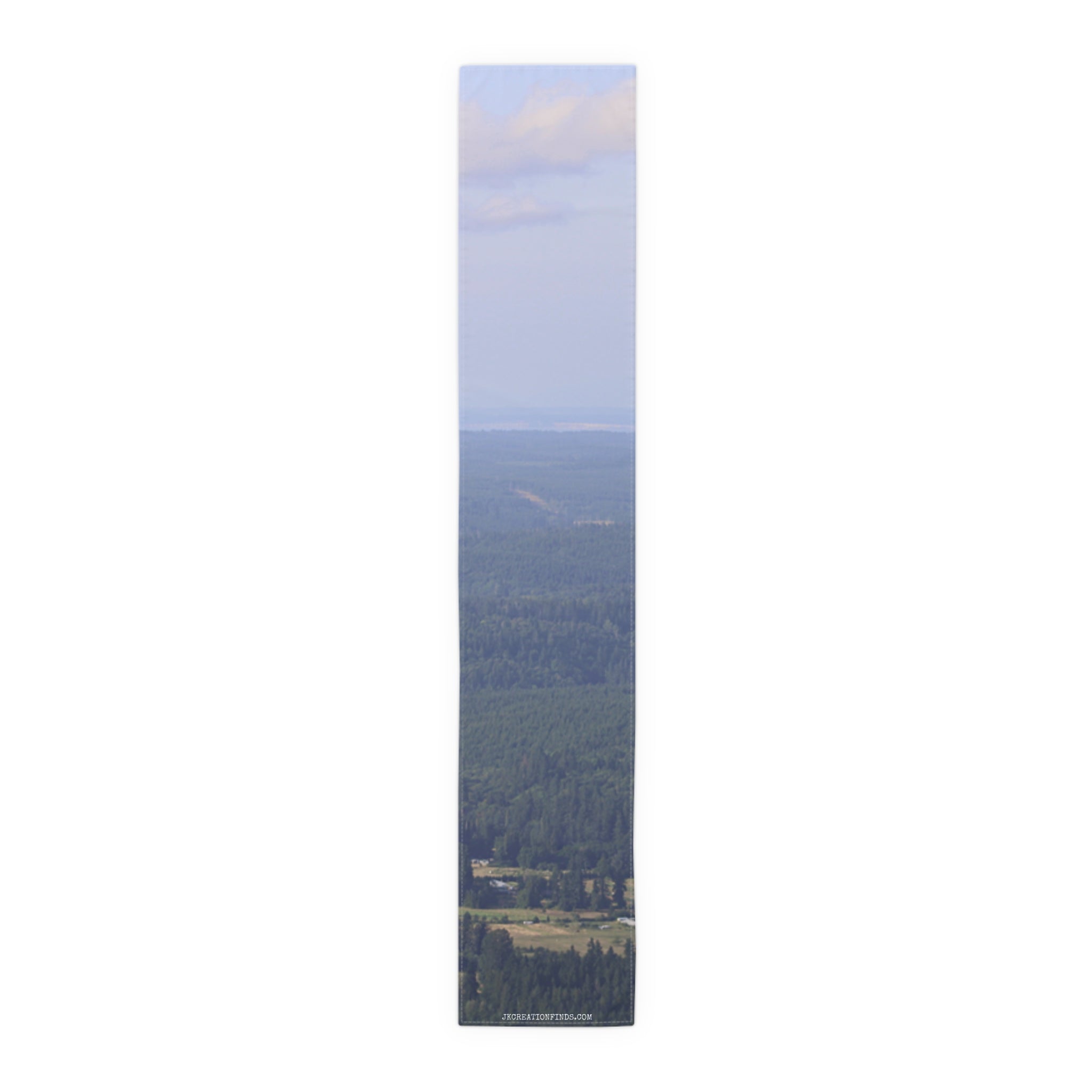 Vertical panoramic view of a dense evergreen forest with a distant hazy sky.