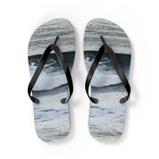 White flip-flops with a wavy blue and grey pattern.