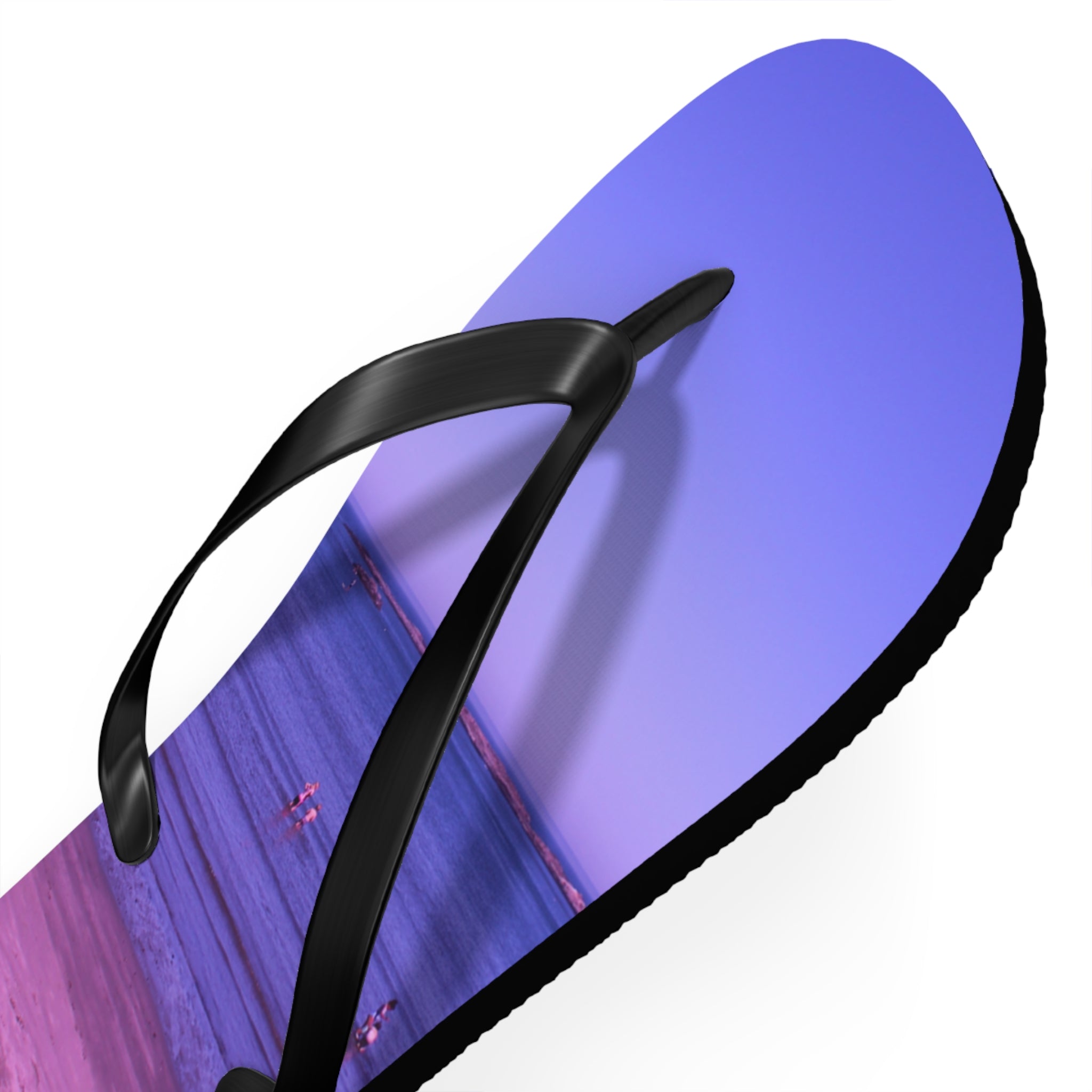 Flip-flop with a beach scene graphic and purple and pink sky.