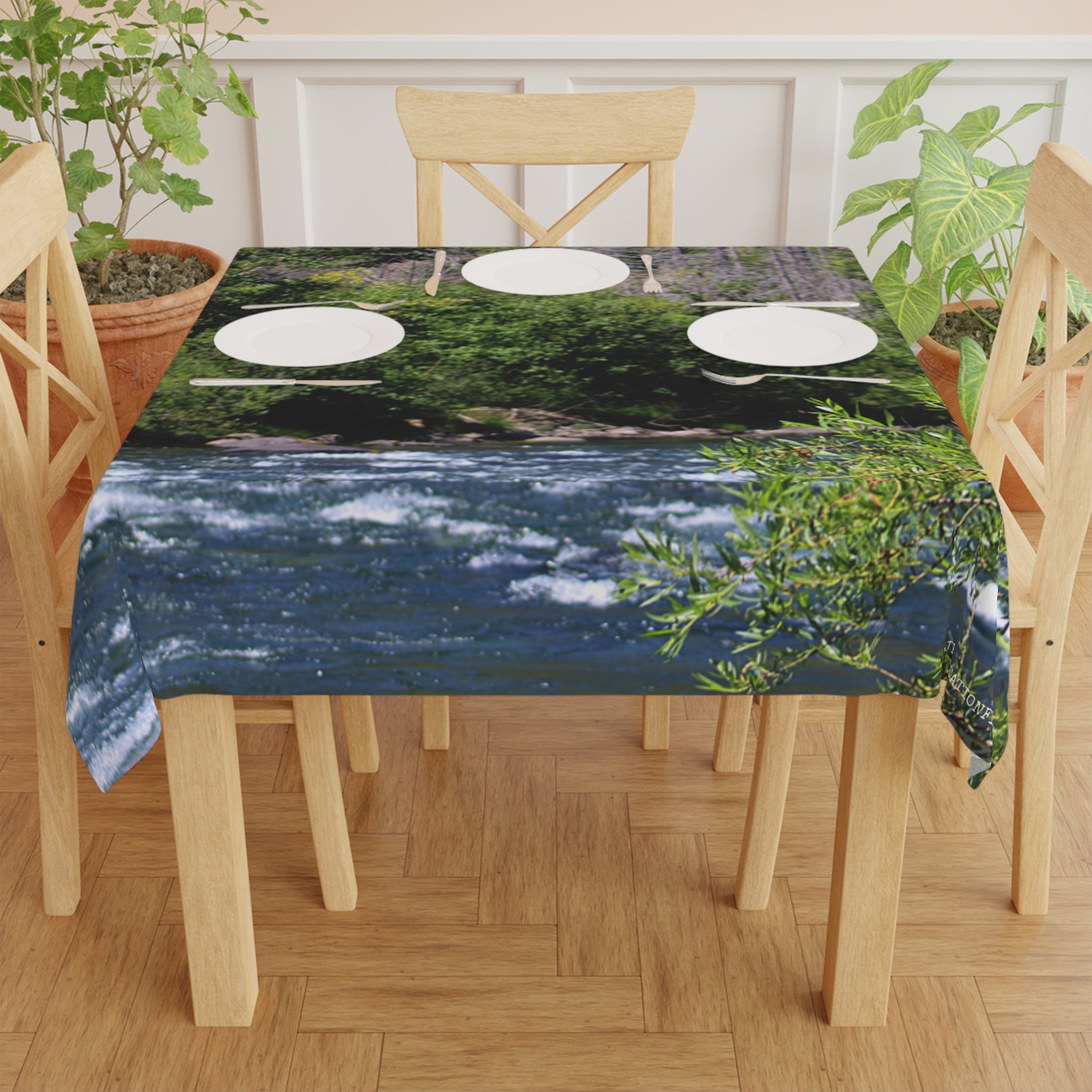 Tablecloth with river rapids and green foliage pattern.