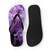 Flip-flops with a close-up floral pattern of purple flowers on the left strap.