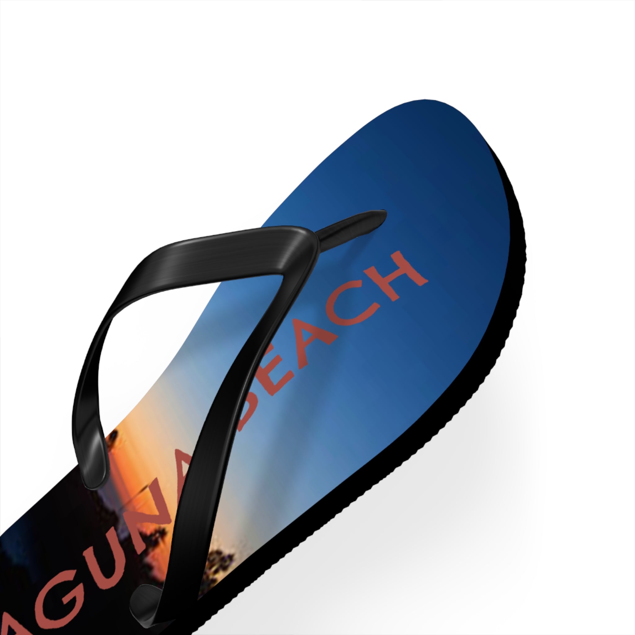 Flip-flops with "LAGUNA BEACH" text over a sunset sky.