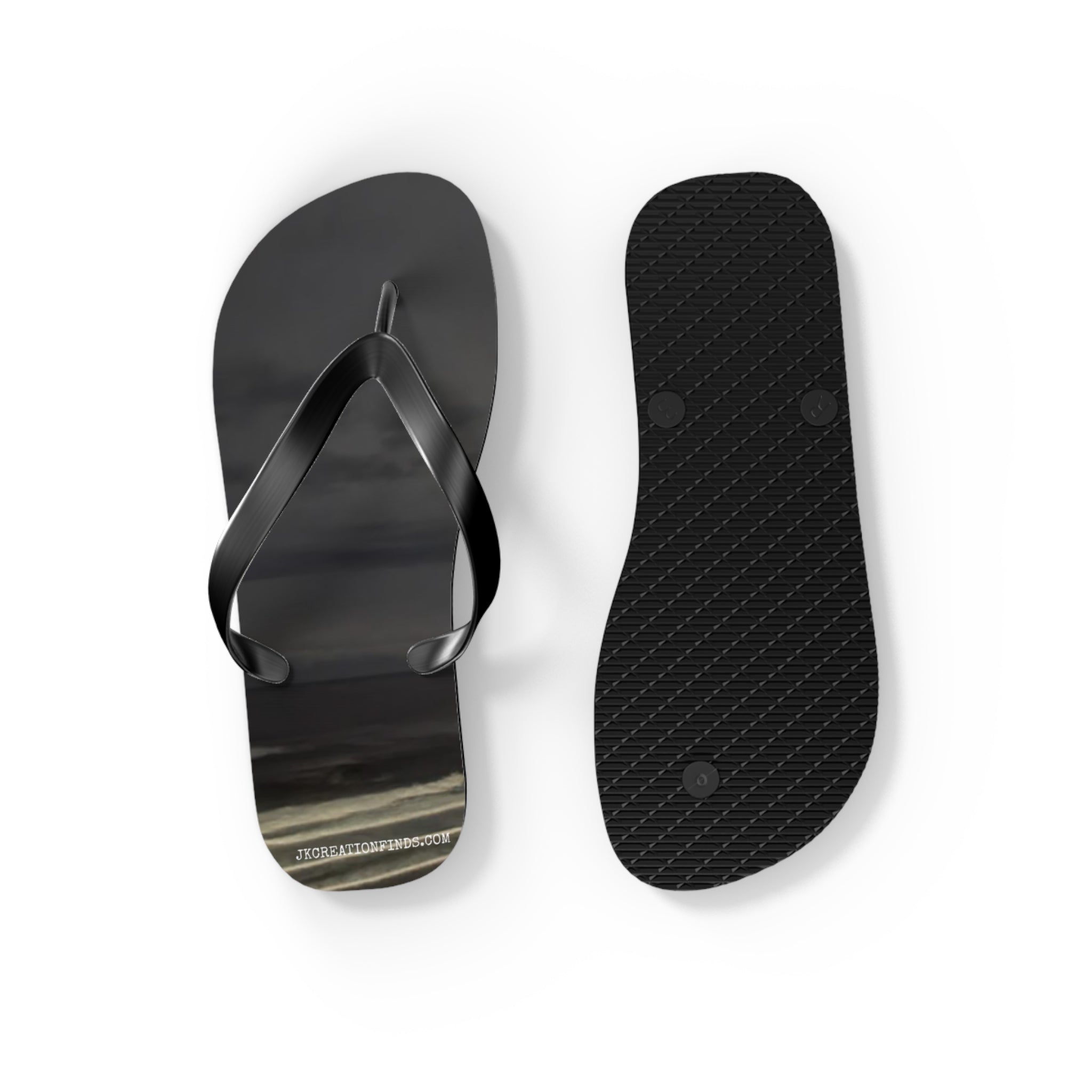 Black flip-flops with abstract patterned soles against a white background.