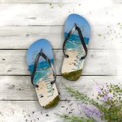 Laguna Beach flip-flops with beach scene on a wooden surface.