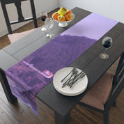 Table runner with purple landscape print, set with plates and silverware.