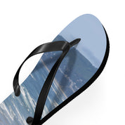 Black flip-flop with ocean wave and beach scenery on sole.