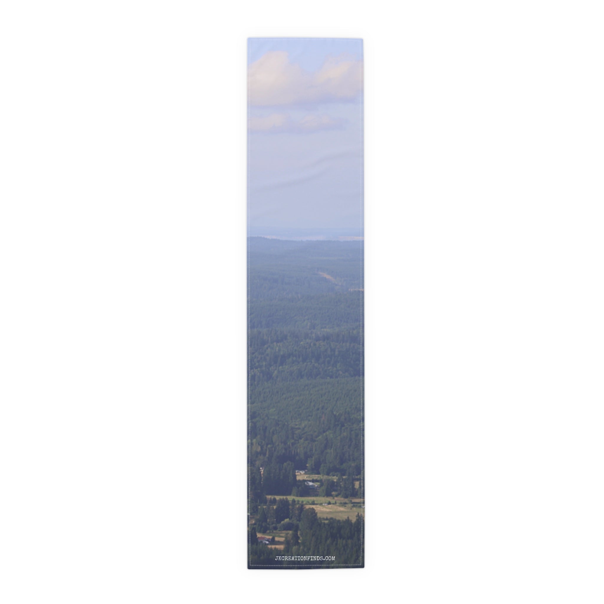 Long, narrow image of a green forest canopy stretching to the horizon with a cloudy sky.