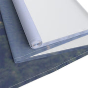 Rolled canvas with blurred forest scene, white background.