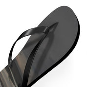 Black flip-flop with a reflective surface displaying a landscape.